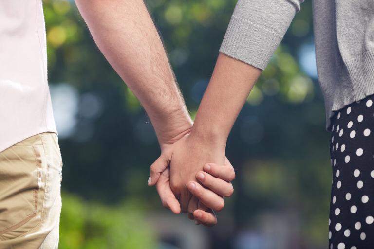 A close up of a couple holding hands