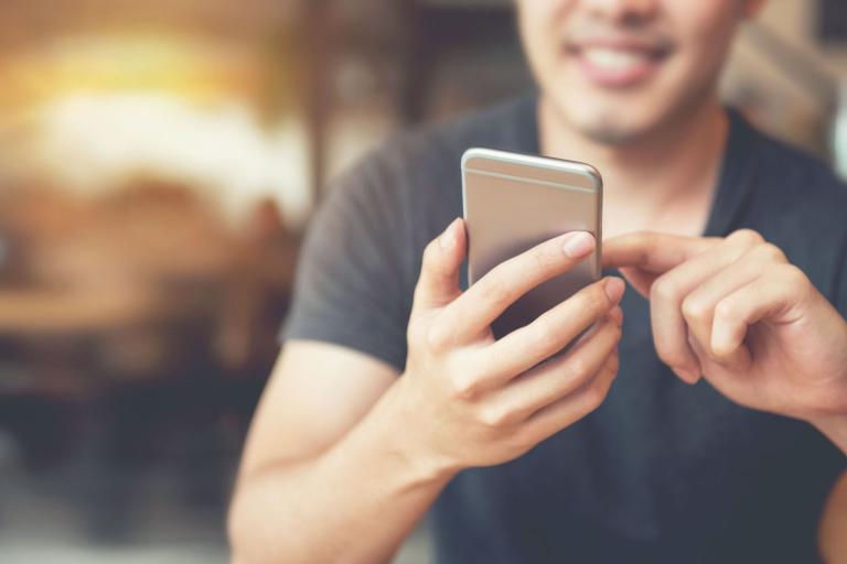 A man scrolling through an app on his phone.