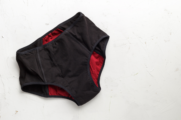 A pair of black and red coloured menstrual pants on a white background.