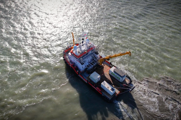 A photo from above of a dredging ship on the sea. 