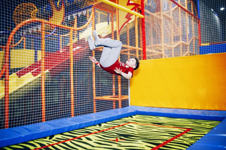 Child jumping on trampoline in soft play area