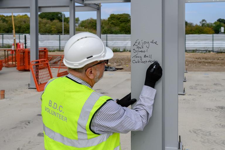 Councillor Tony Ball signs the newly erected steel at Limebrook Primary School and Nursery