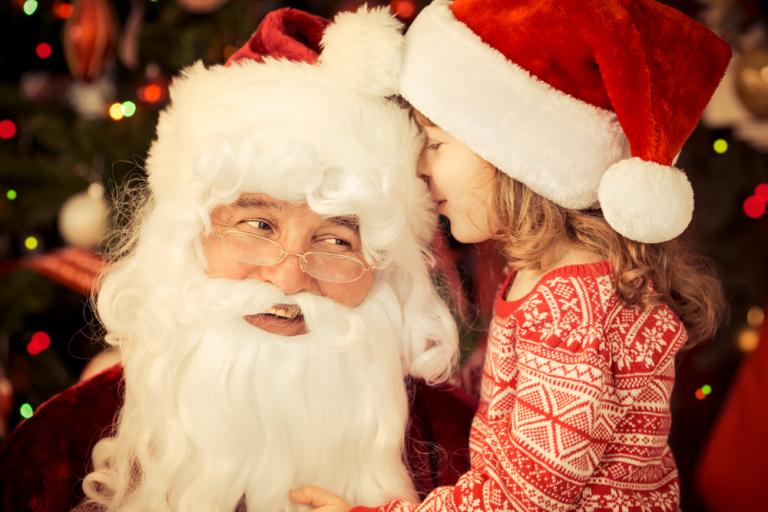 Santa Claus with a young child in santa hats 