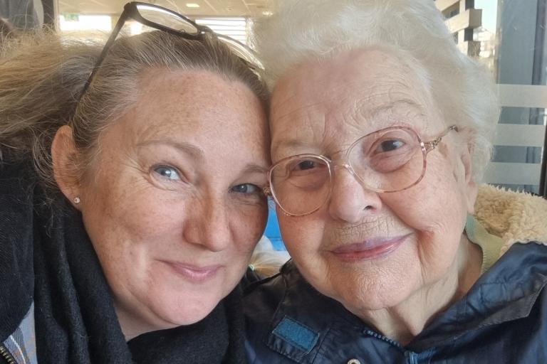 Two women sitting in a restaurant smiling.