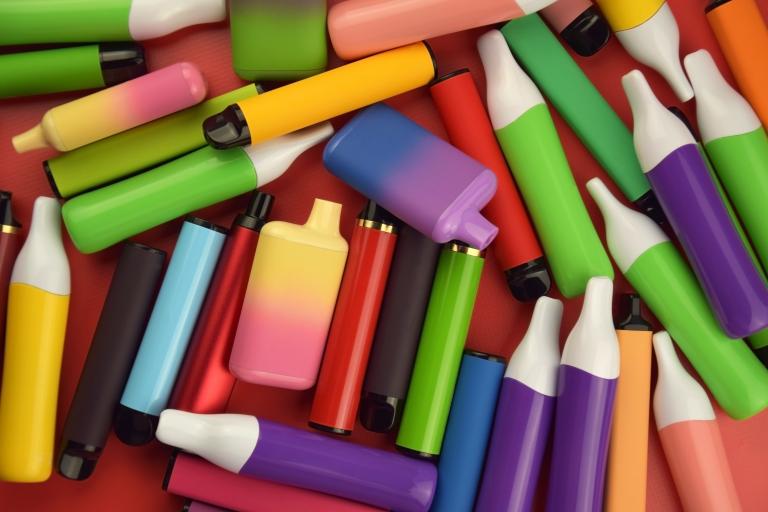 Multi-coloured vapes spread out across a red background.
