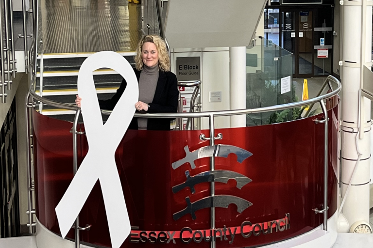 Cllr Louise McKinlay standing next to a large white ribbon