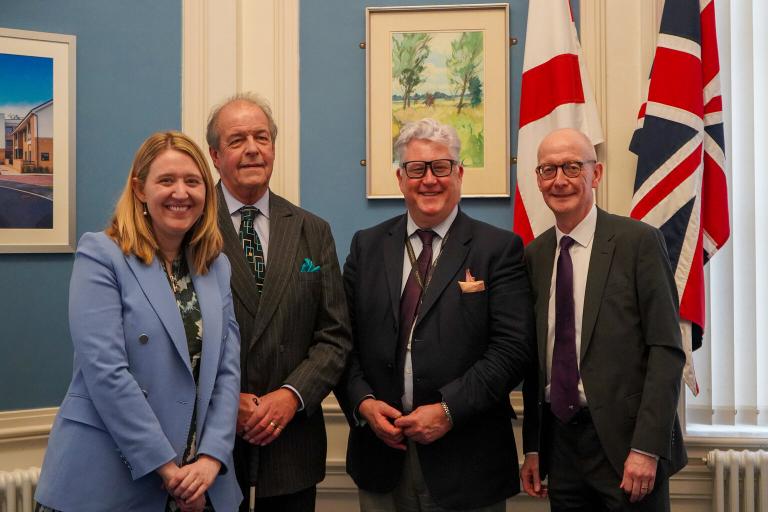 Four people standing in an office.