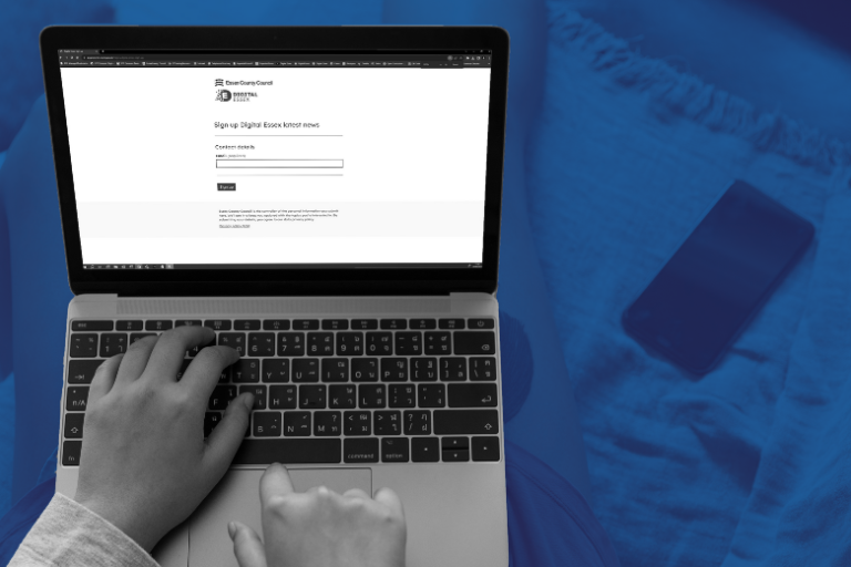 hand typing on laptop keyboard with blue background