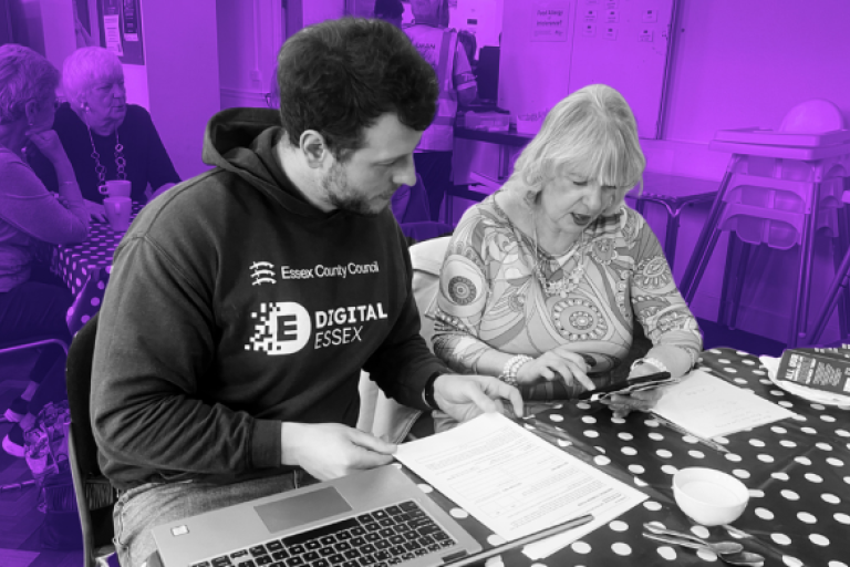 person from digital essex helping another person access the internet on a tablet