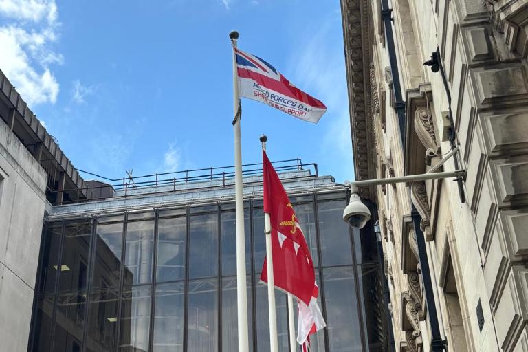 Flag flies above county hall in front of blue sky