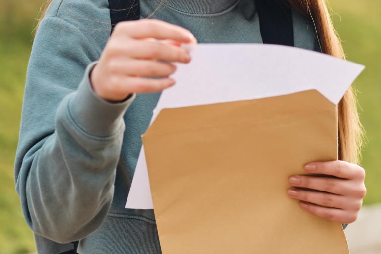 Teenage girl opening exam results.