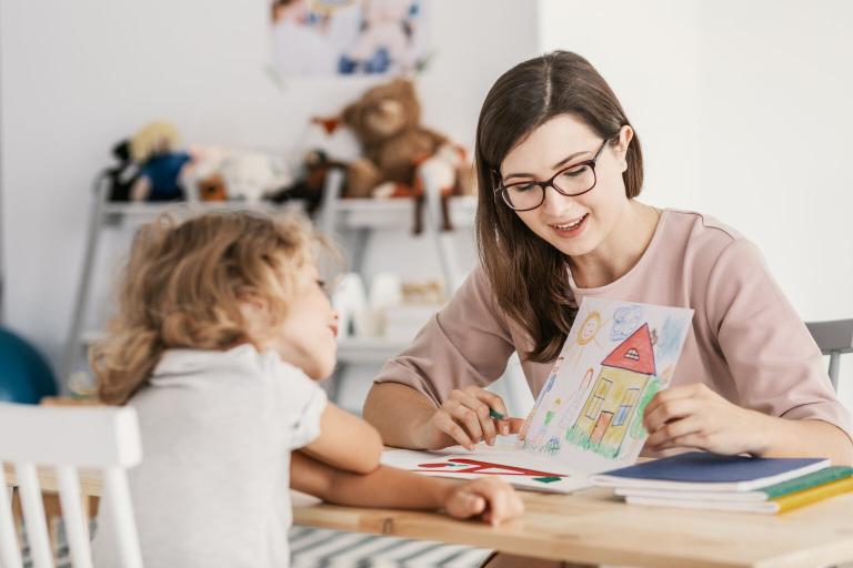 A lady reading with a young child.