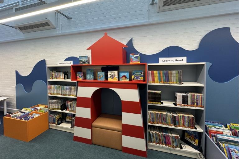 A large selection of books on brightly decorate shelves.
