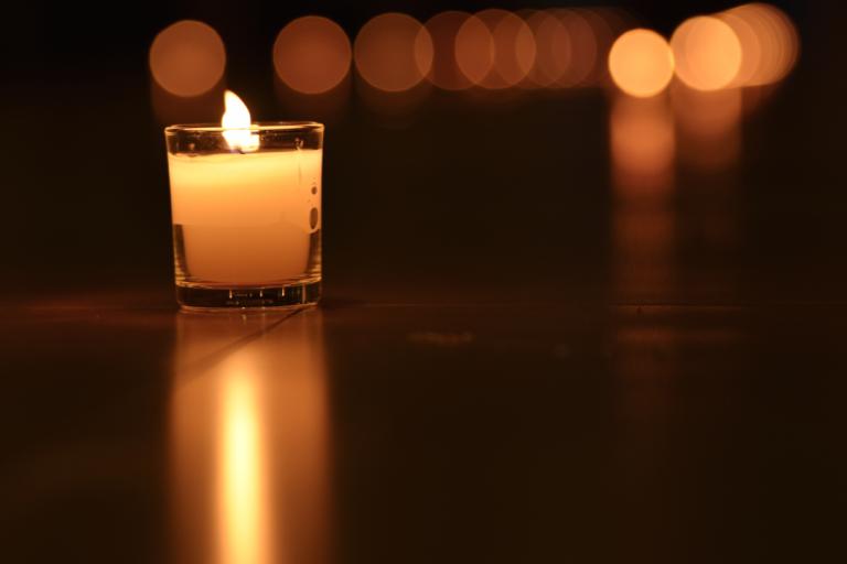 A lit candle in a dark room.