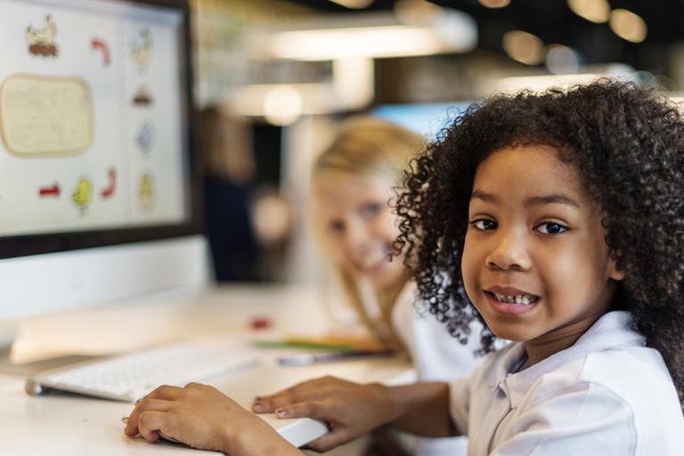 Two young children at a computer
