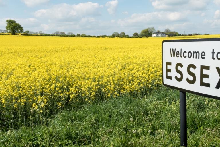 A Welcome to Essex sign in front of a field