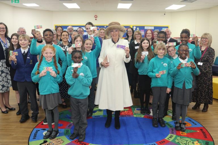 The Queen Consort poses for a photo with children and staff during her visit to Colchester Library.