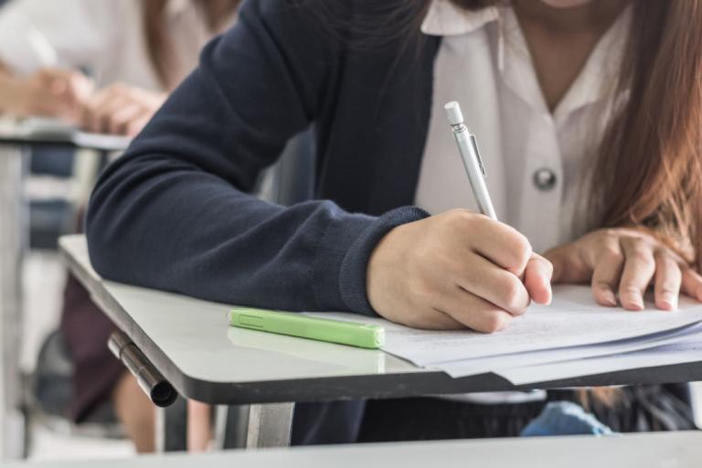 A female students taking an exam at a desk.