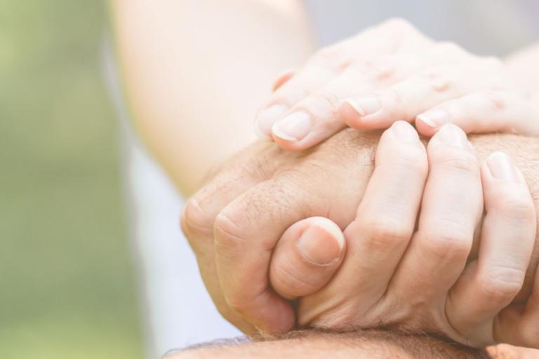 A close up of two people holding hands.