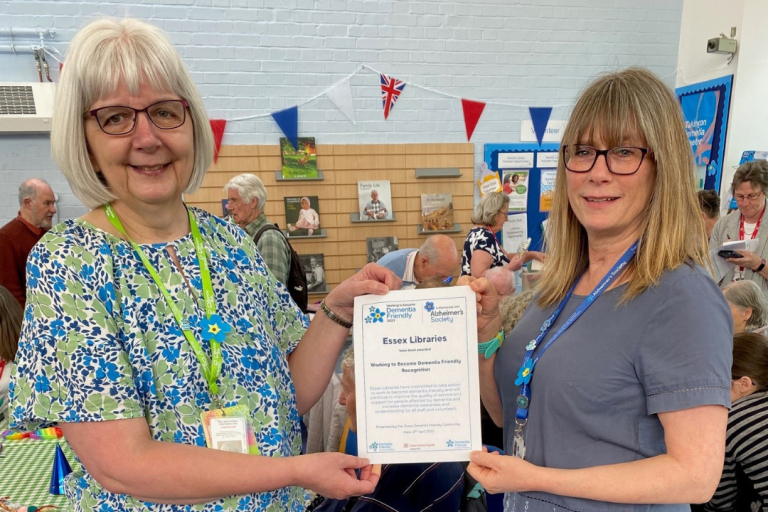Michele Price of Essex Library Service accepts the certification from Clare Young of Alzheimer's UK