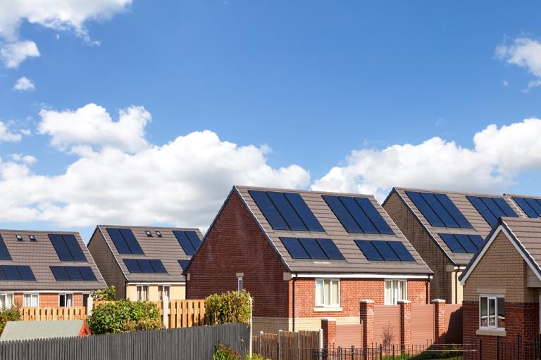A row of new build houses with solar panels on the roof.