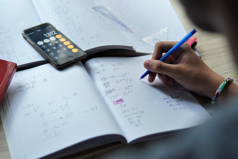 A man doing some mathematics work at a desk 