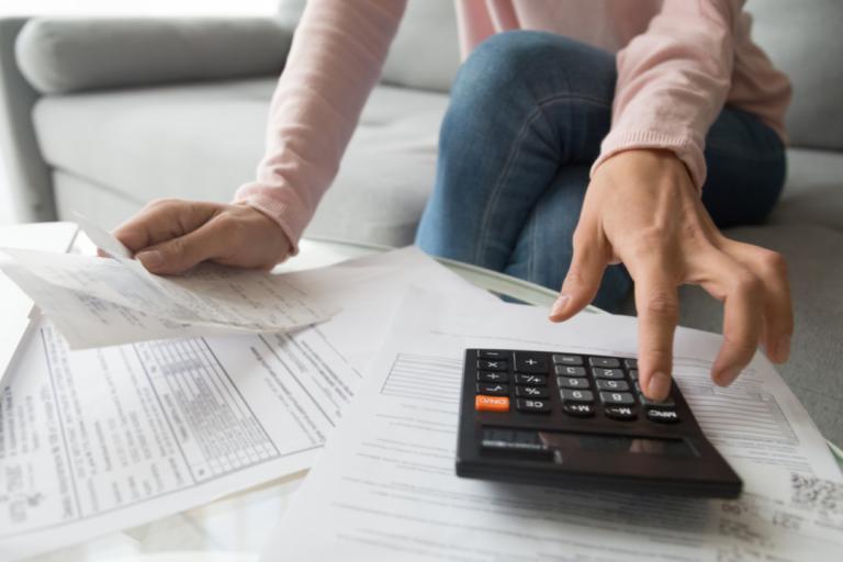 A woman with a calculator looking at her bills.