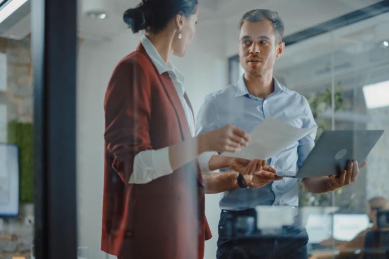 A man and a woman speaking inside an office.