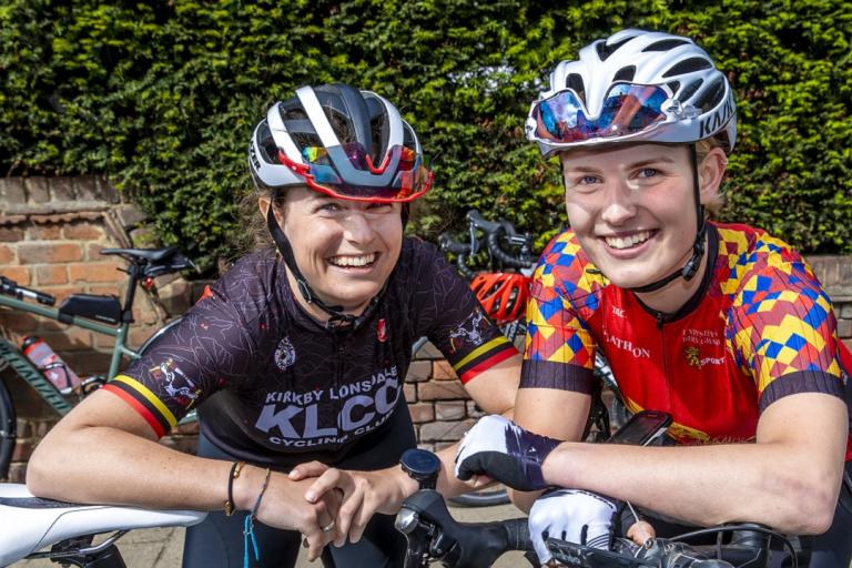 Two female participants in last year's Ride-London dressed in cycling gear with their bikes.