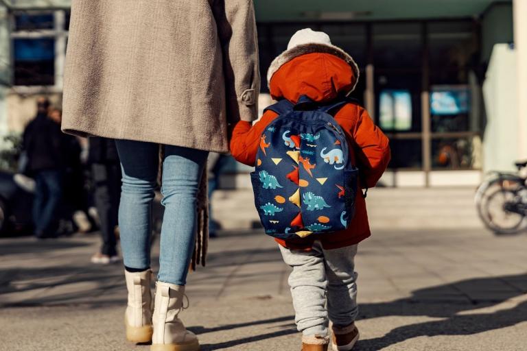 A mum walks hand in hand with her child.