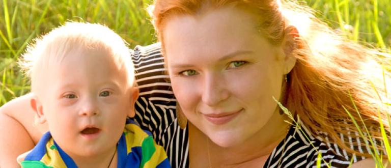 smiling lady with child sitting on grass